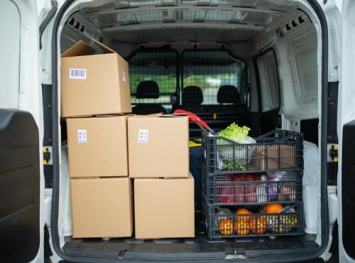 Packed delivery van with boxes and fresh produce crates for efficient logistics.
